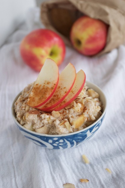 Oatmeal in a blue bowl with red apple slices