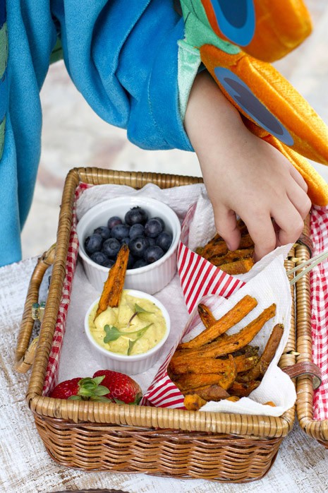 Little boy reaching into a red checker picnic basket