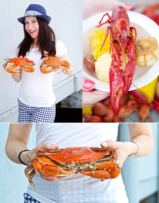 Lady in fedora hat holding freshly caught crabs, crawfish and corn